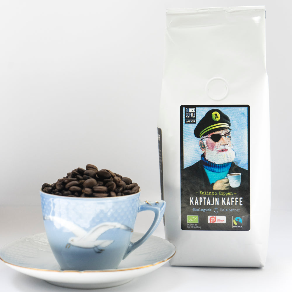 Kaptajn Kaffe, økologisk og fairtrade certificeret kaffe i en pose på 200g, hele bønner i en kop mågestel